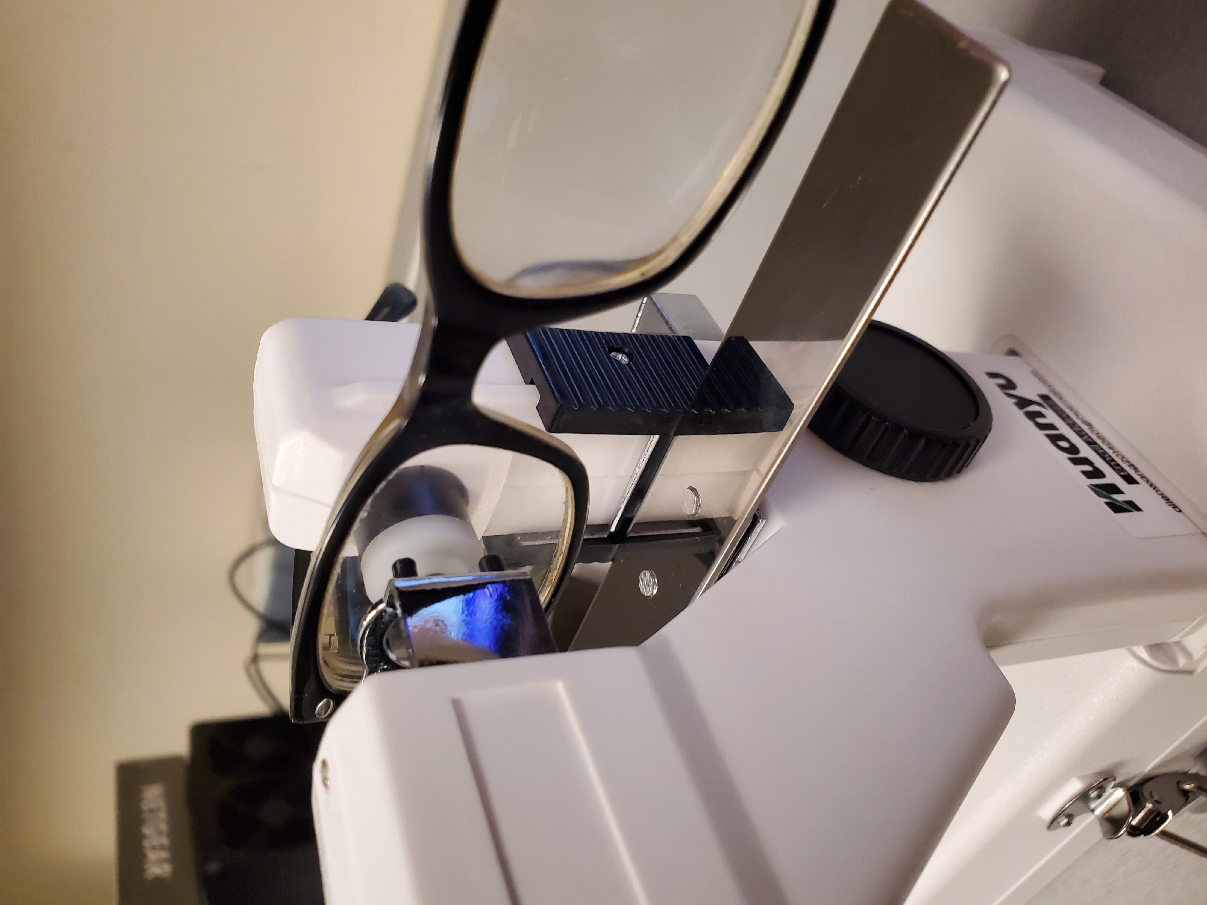 5. Use the tool to grip the lens and rest the glasses on the stand if necessary.